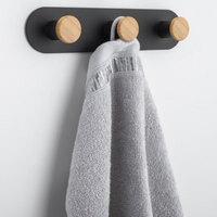 Triple hook rail pairing matte black metal with natural wood