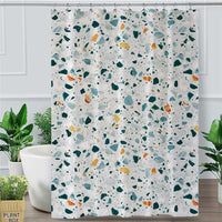 Green, blue, mustard and black terrazzo chips scattered on off-white