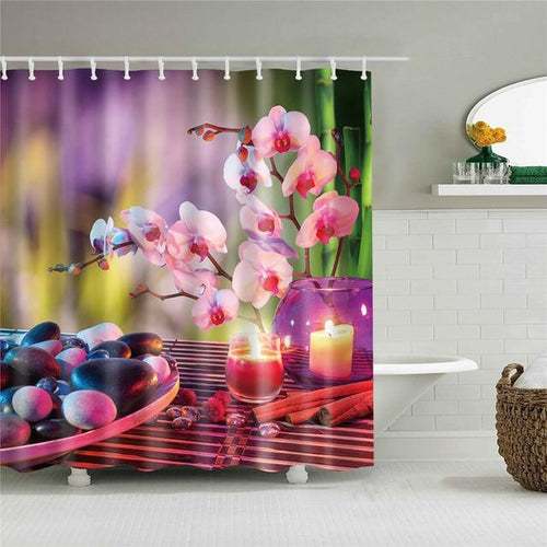 Pink orchids lit candles and smooth stones on a warm violet ground