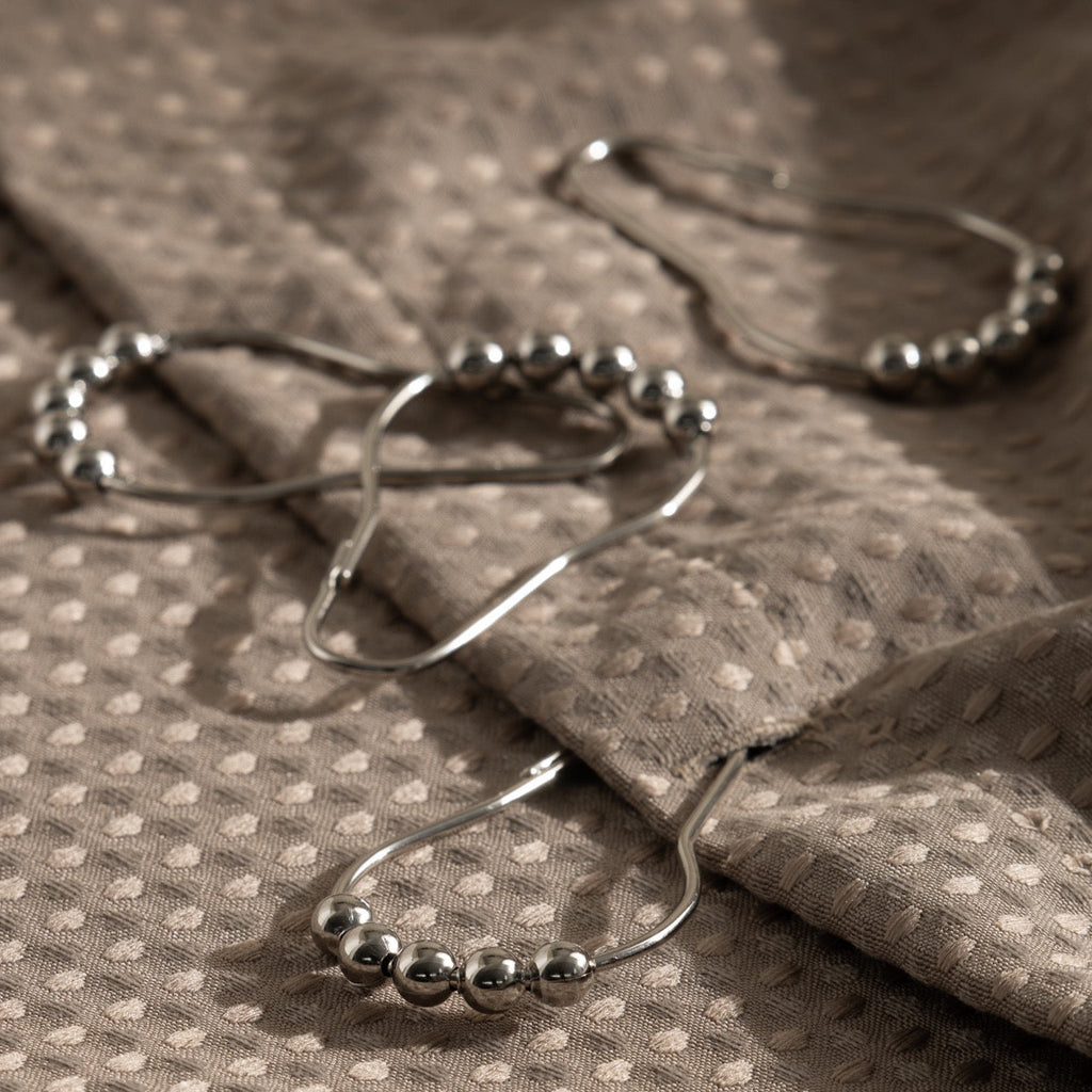 Close view of the beaded crown on a satin silver curtain ring