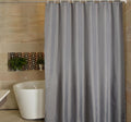 Plain mid grey panel hanging in even folds in a bathroom