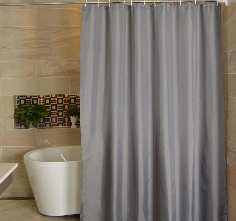 Plain mid grey panel hanging in even folds in a bathroom