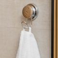 Brushed silver self-adhesive towel hook mounted on a tiled wall