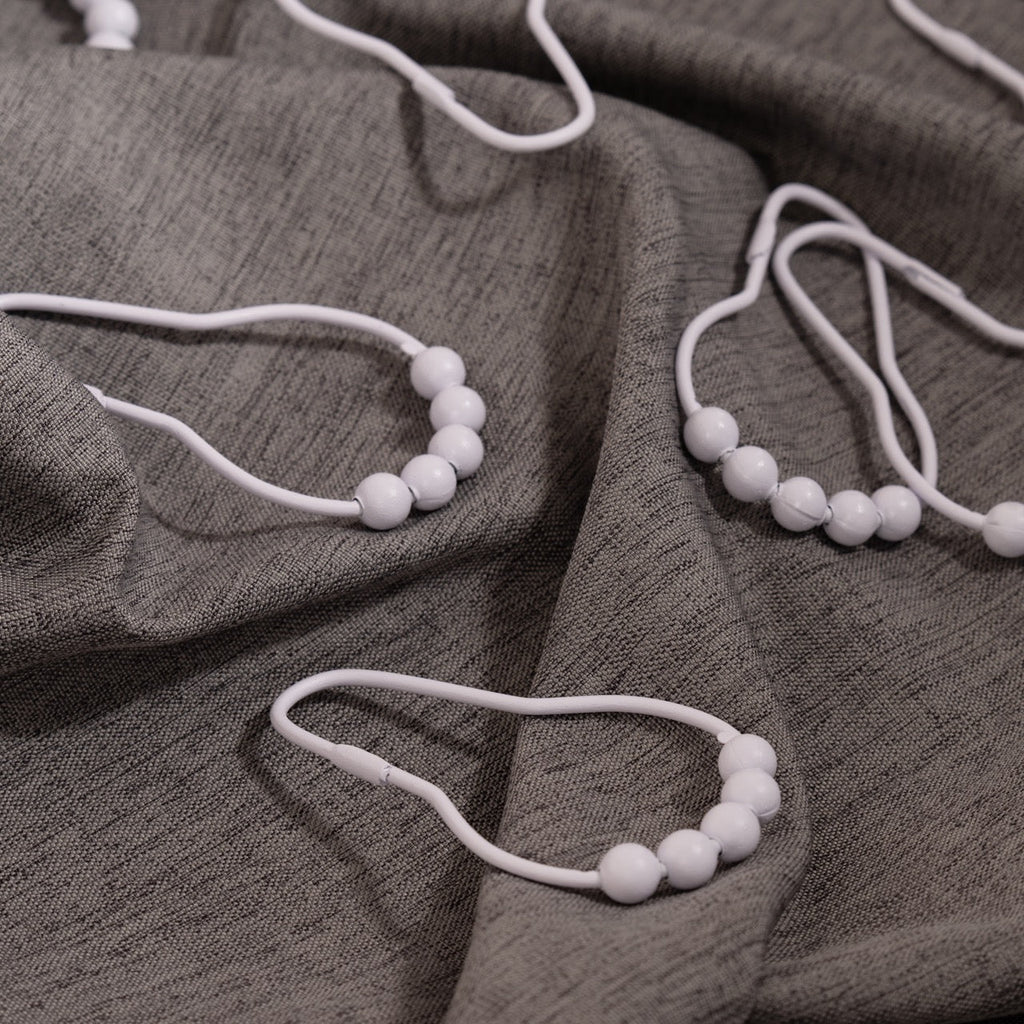 Close view of the white bead crown on a single curtain ring