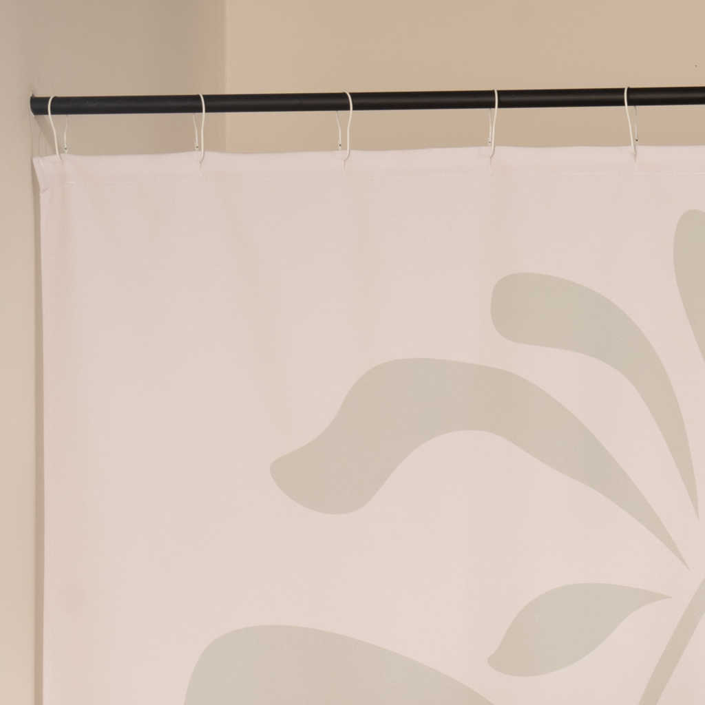 Full length beige branch curtain hanging beside a glass screen