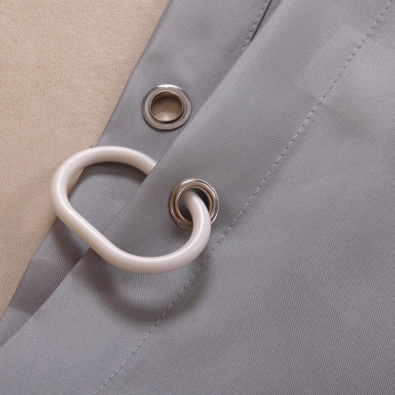 Full length grey fabric curtain hanging straight beside a bathtub