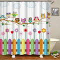 Row of colorful owls perched on a branch above flowers and a fence