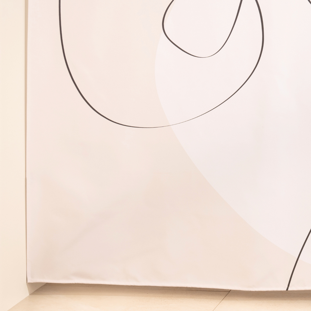 Full length abstract line curtain hanging beside a glass screen