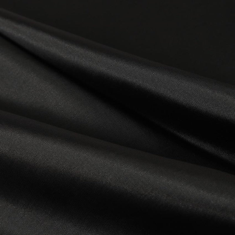 Solid black curtain styled in a bright contrasting white bathroom