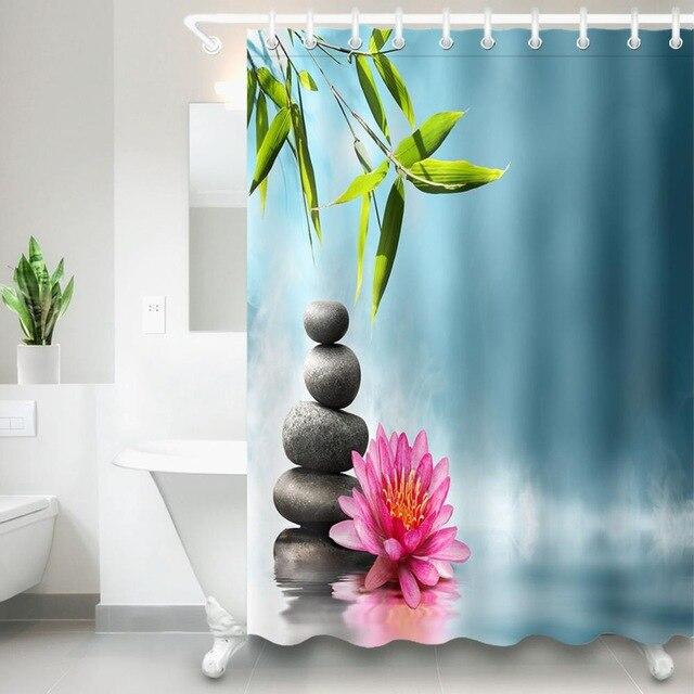 Bright bamboo leaves above stacked black pebbles and a pink lotus on turquoise