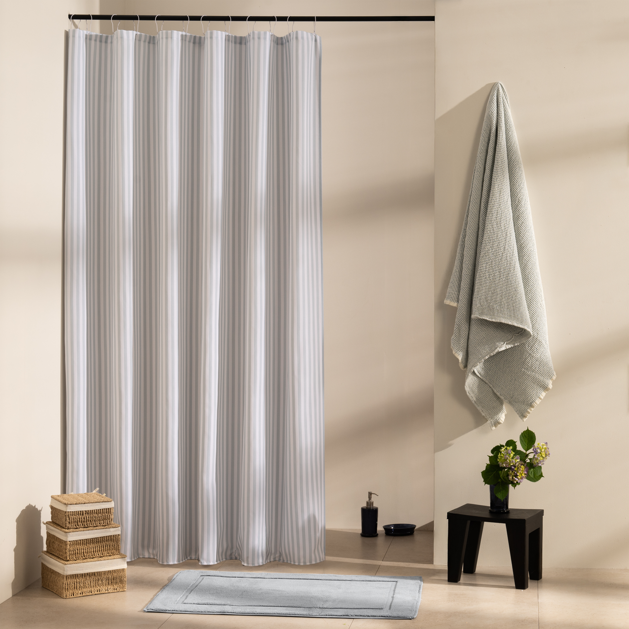 Blue grey vertical stripes on white beside a matching blue towel