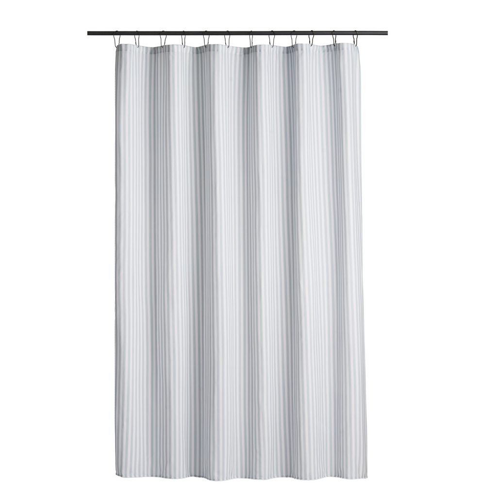 Blue striped curtain styled in a bright bathroom with white tiling