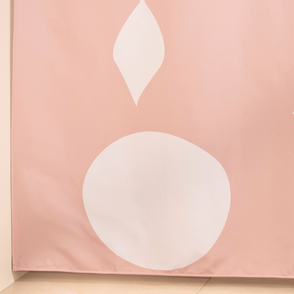 Full length botanical pink curtain hanging beside a glass screen