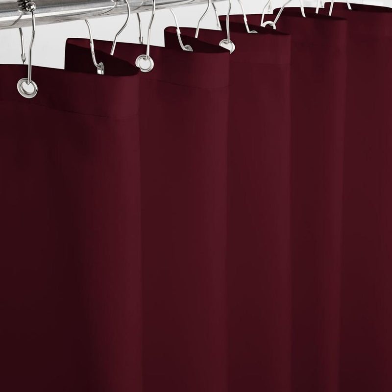 Full length burgundy curtain hanging straight beside a white bath