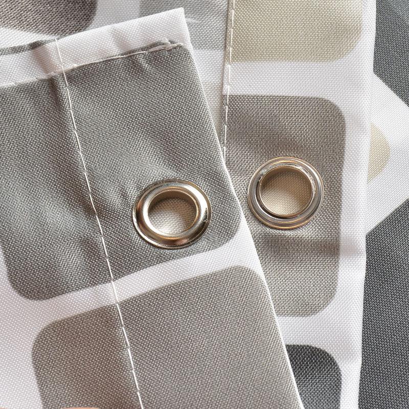 Full length checkered curtain hanging beside a neutral bathroom wall