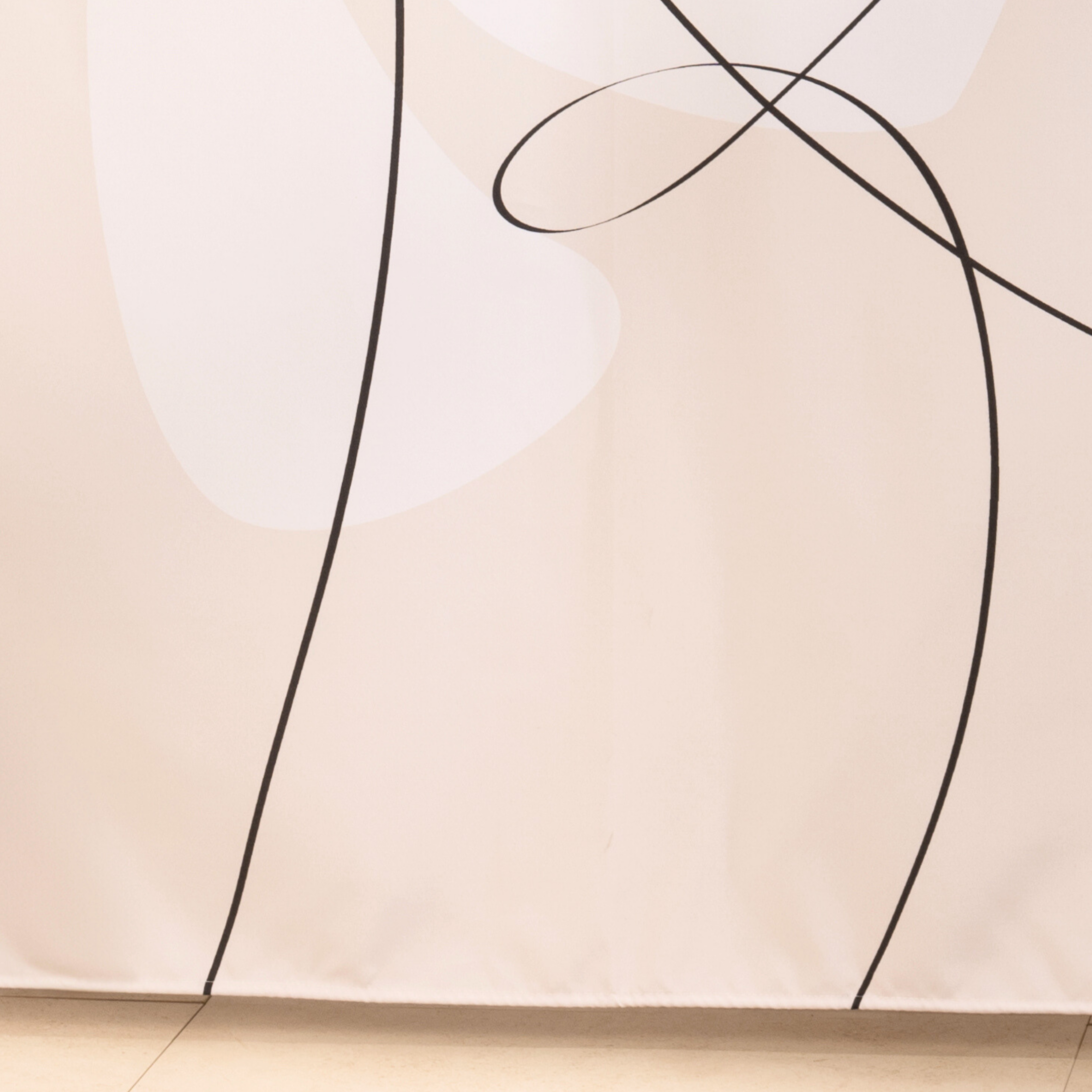Full length line art curtain hanging beside a glass shower screen