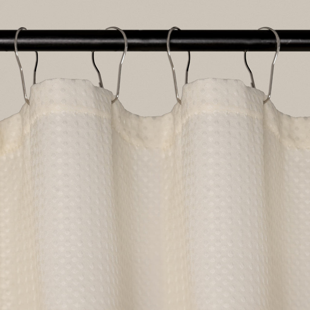 Weighted lower hem holding the cream panel in a straight even fall