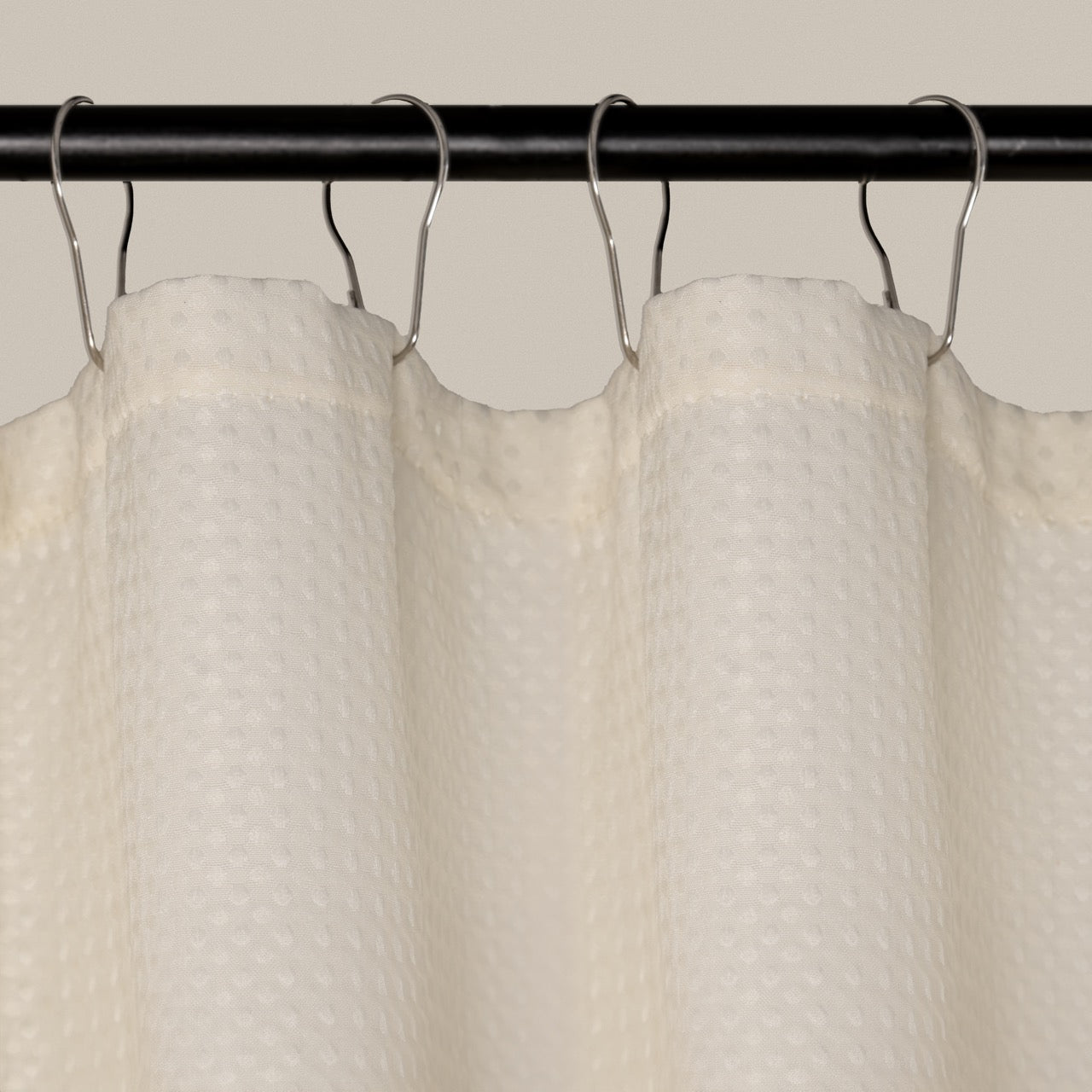 Weighted lower hem holding the cream panel in a straight even fall