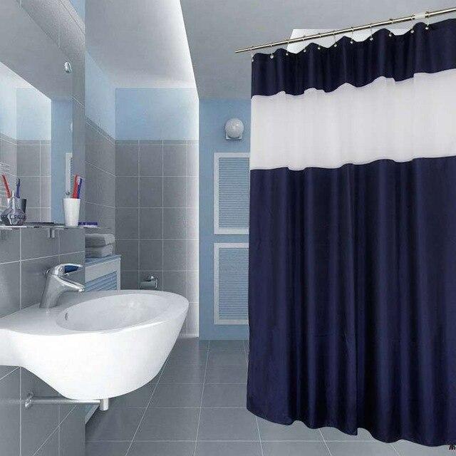 Full length navy and white curtain hanging beside a white bathtub