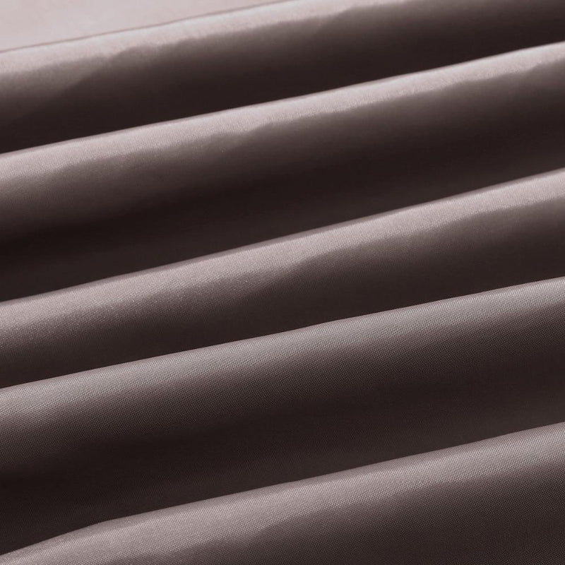 Full length chocolate brown curtain hanging beside a white bathtub