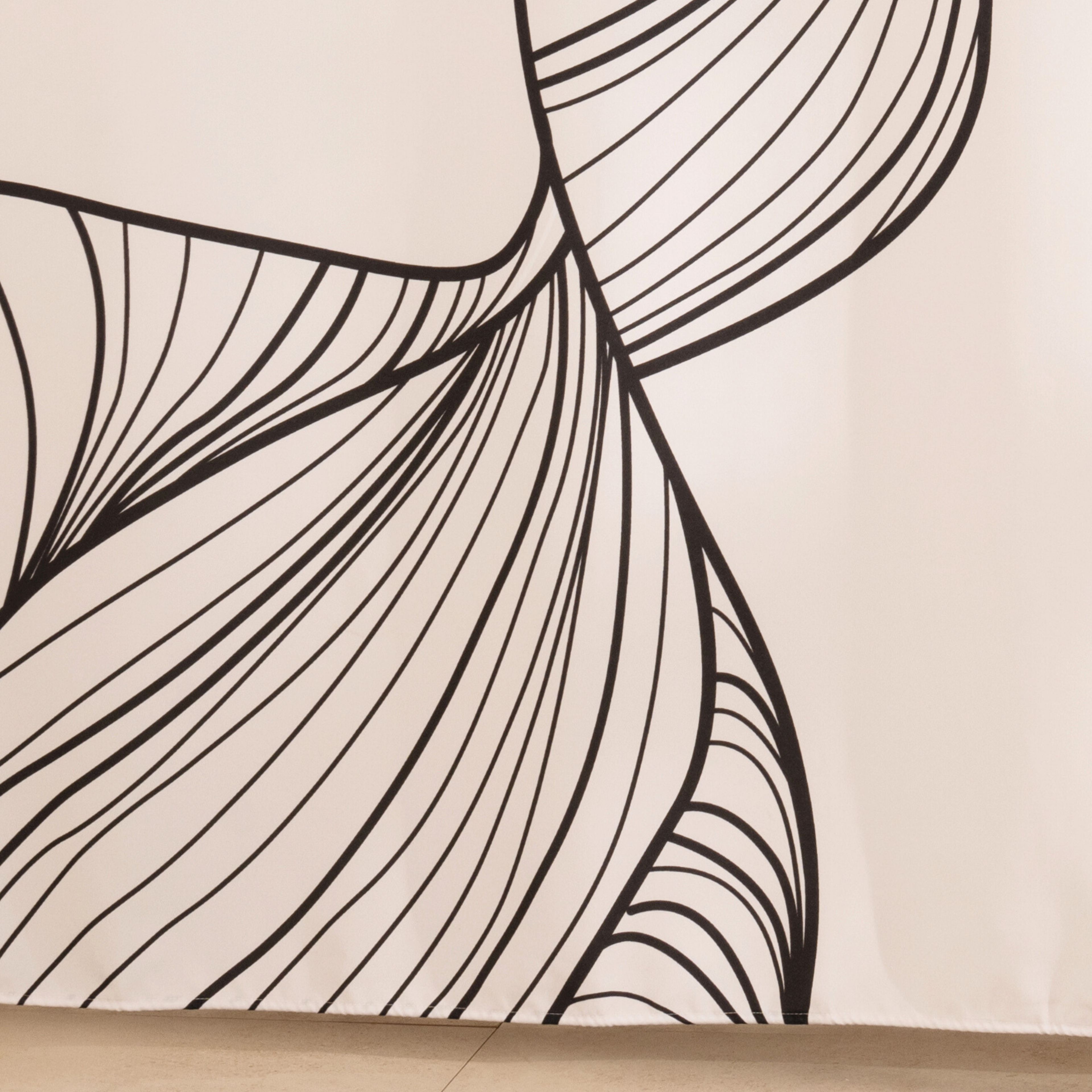 Full length designer curtain hanging beside a glass shower screen