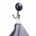 Matte black double towel hook mounted on a smooth tiled wall