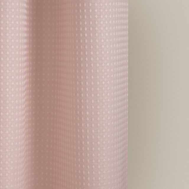 Full length dusty rose curtain hanging beside a glass shower screen