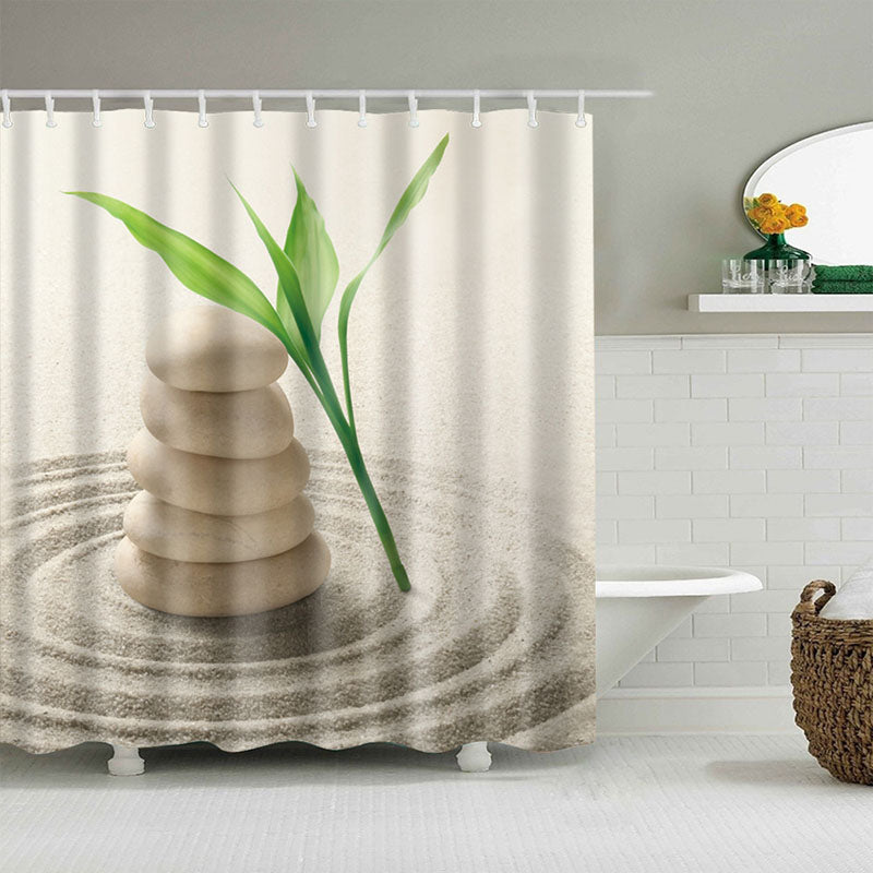 Beige stones and a green shoot at the centre of circles traced in sand