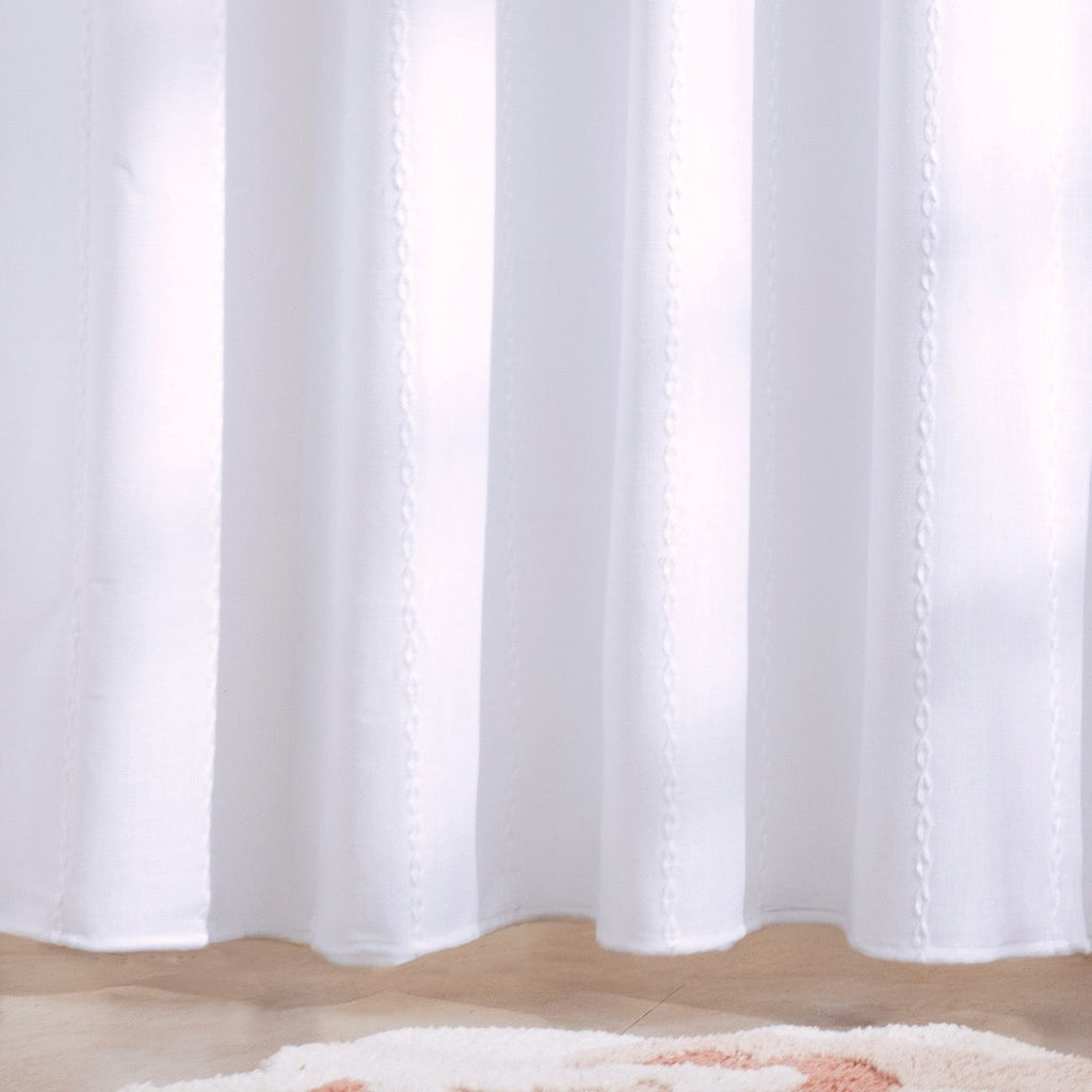 Full length white ribbed curtain hanging beside a walk in shower