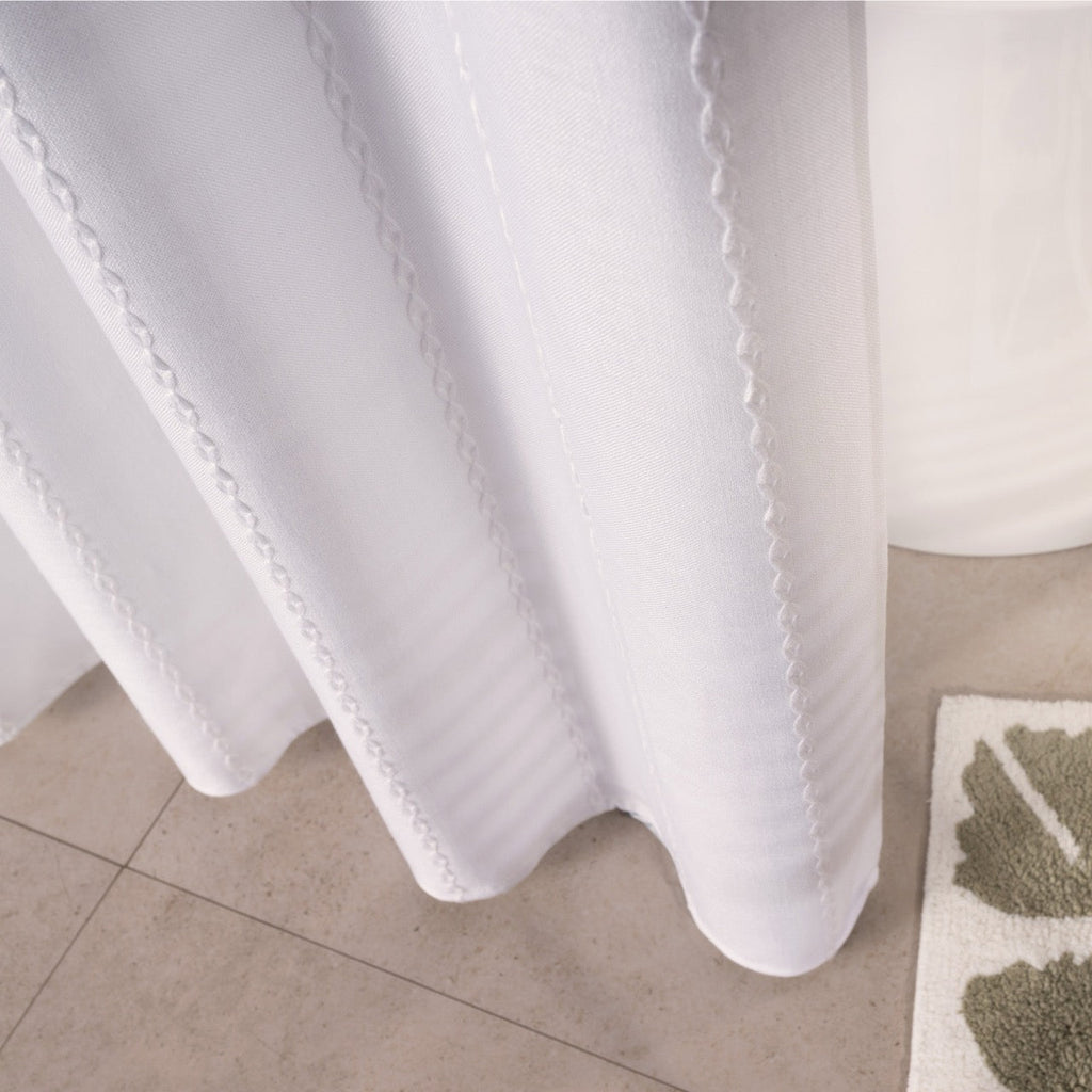 White ribbed curtain styled in a calm bathroom with pale tiling