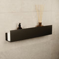 Large black stainless steel floating shelf mounted on a tiled wall