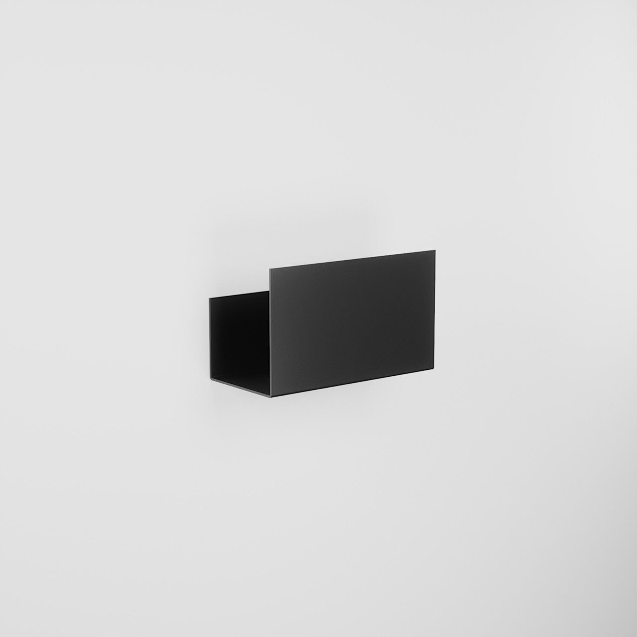Close view of the small black shelf holding two bottles above the tiles