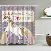 Rainbow-maned unicorn rearing on a pastel arc over a grey heart-strewn ground