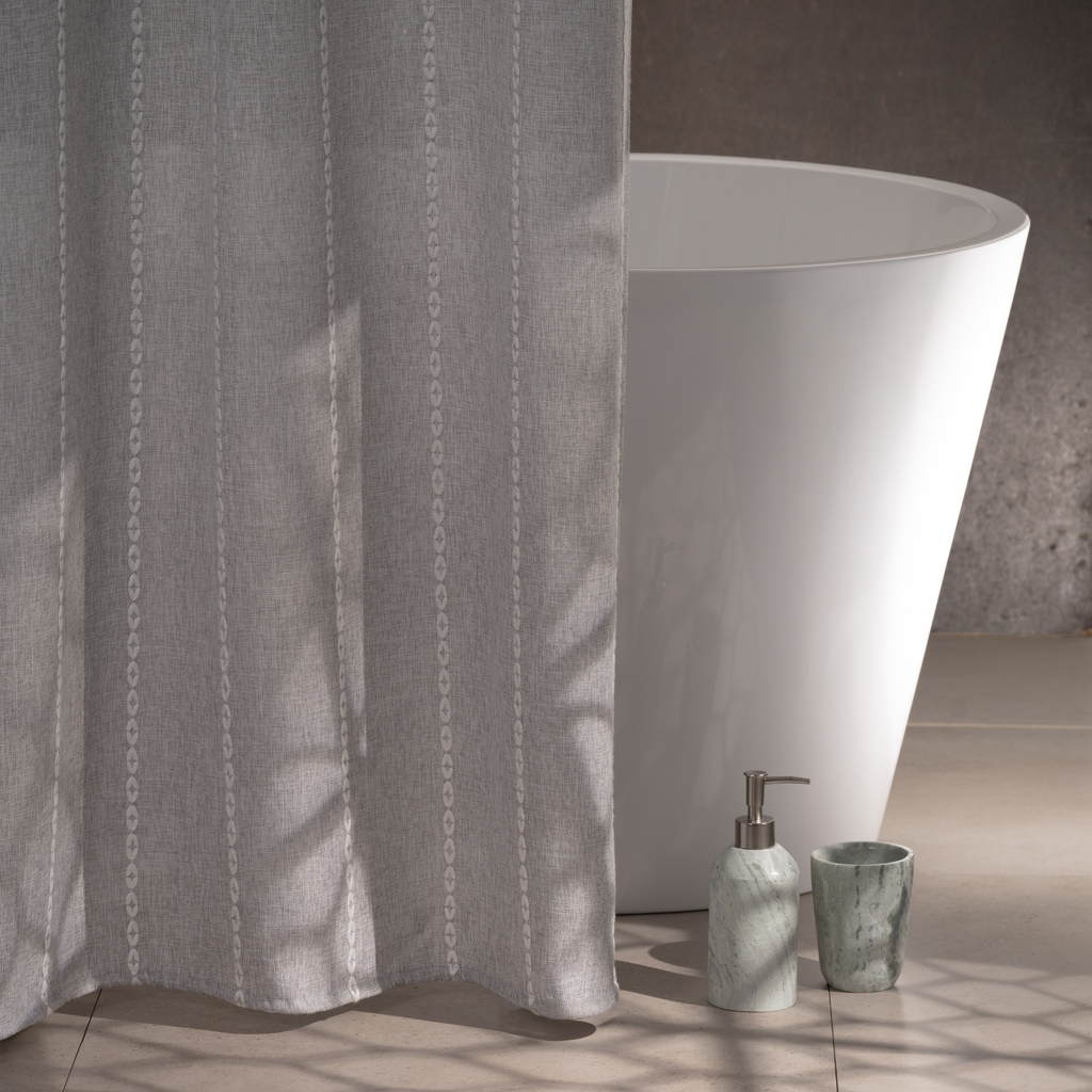 Grey curtain styled in a modern bathroom with white tiled walls