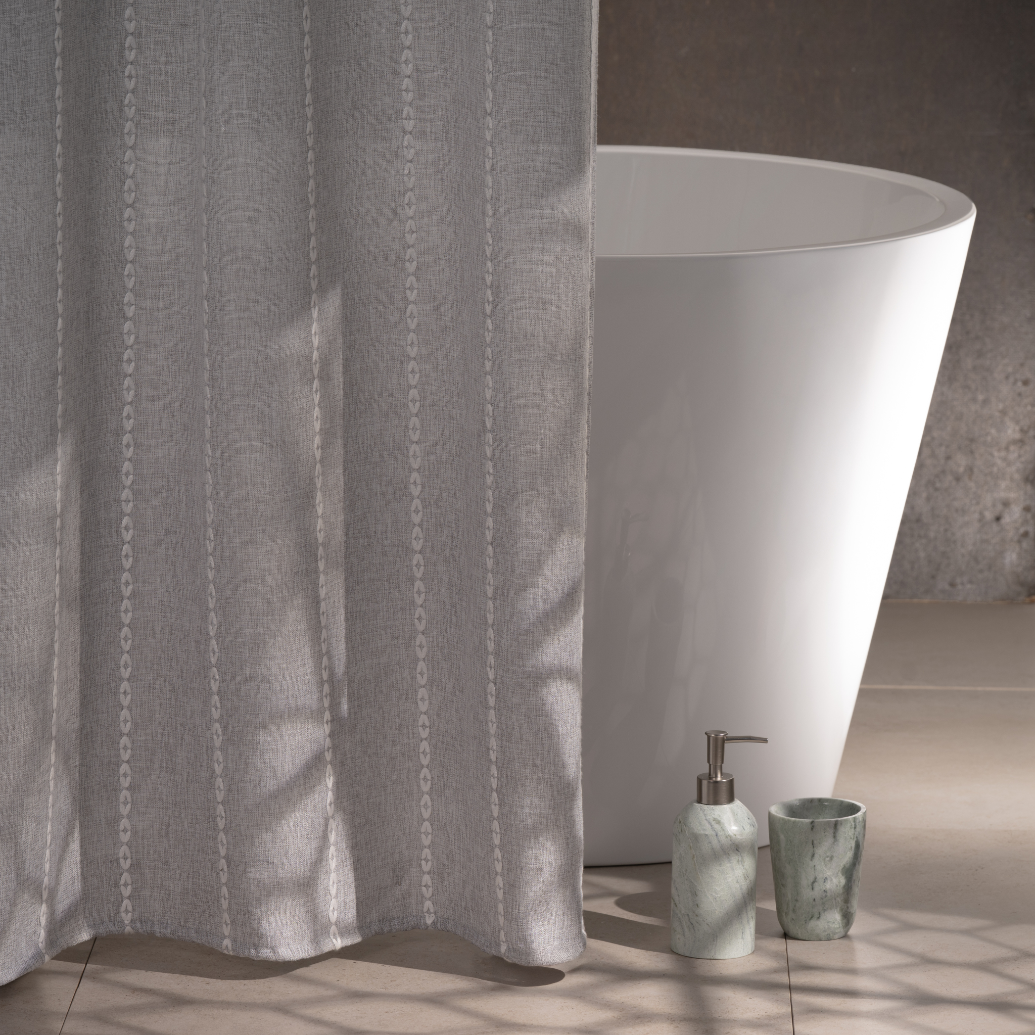 Grey curtain styled in a modern bathroom with white tiled walls