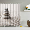 Stacked grey stones resting on beige sand raked into concentric circles
