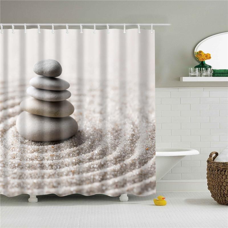 Stacked grey stones resting on beige sand raked into concentric circles