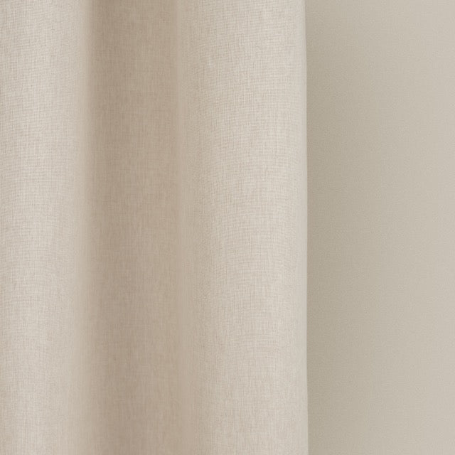 Full length ivory curtain hanging beside a glass shower screen