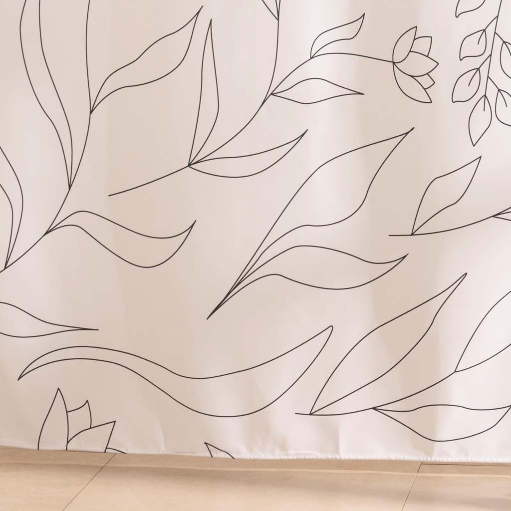 Full length leaf line curtain hanging beside a glass shower screen