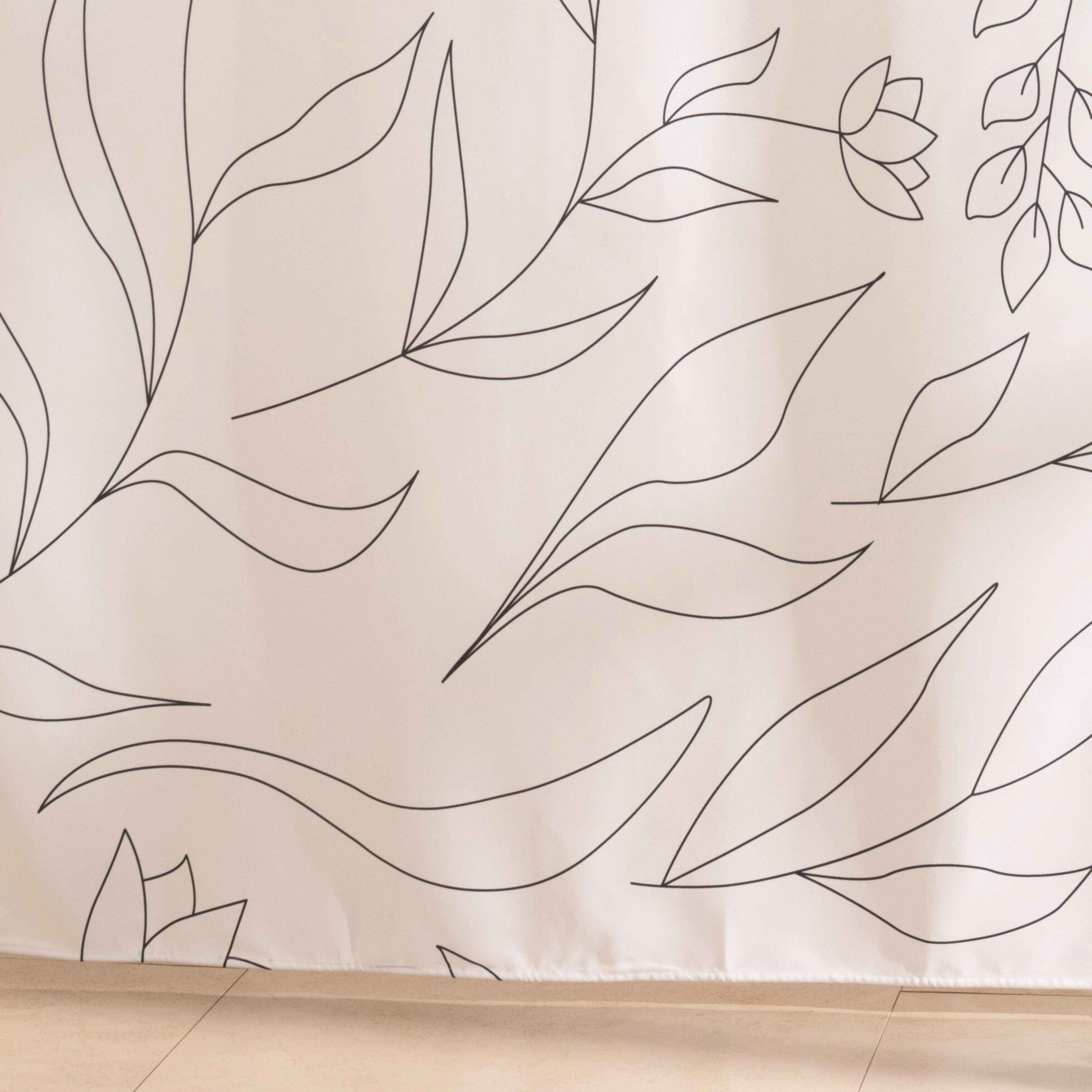 Full length leaf line curtain hanging beside a glass shower screen