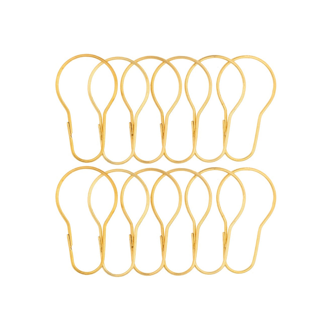 Twelve bright gold pear shaped curtain rings laid out in two rows