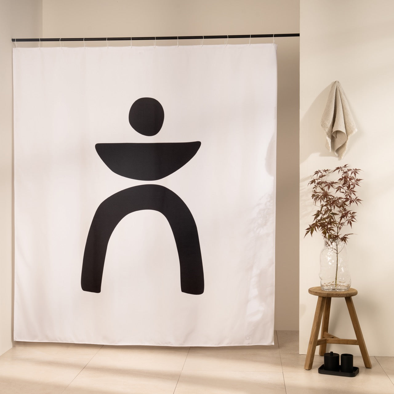 Bold black shape of a disc, bowl and two arched legs on bare white