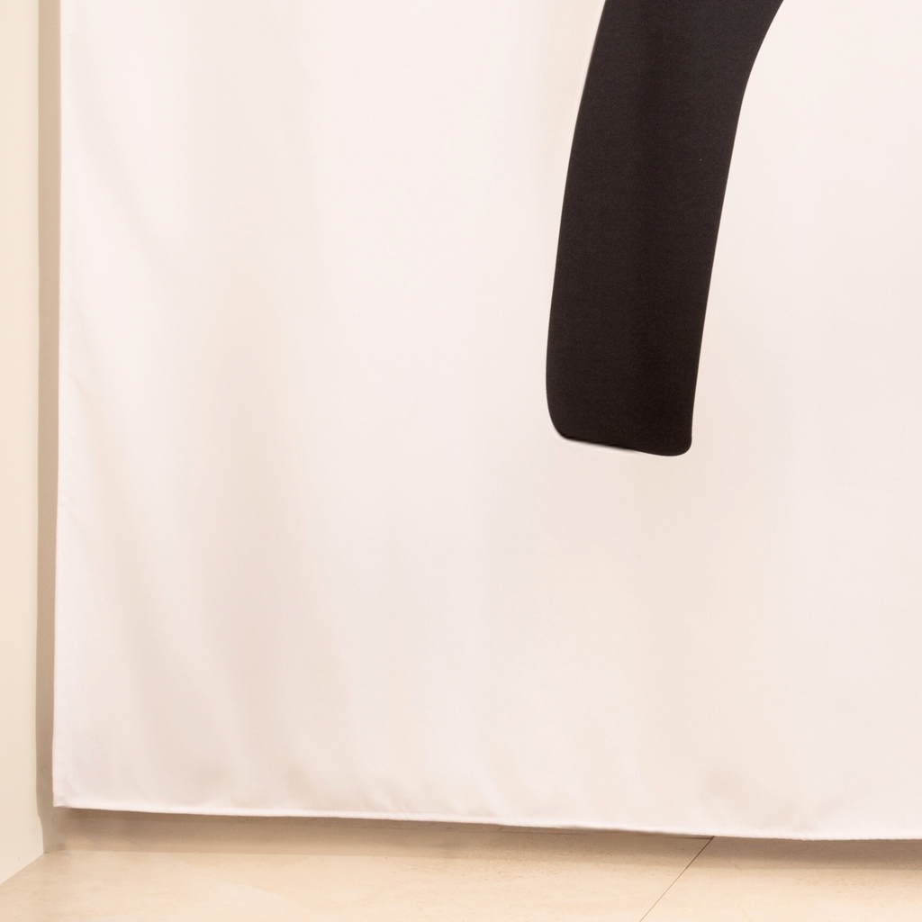 Full length bold abstract curtain hanging beside a glass screen