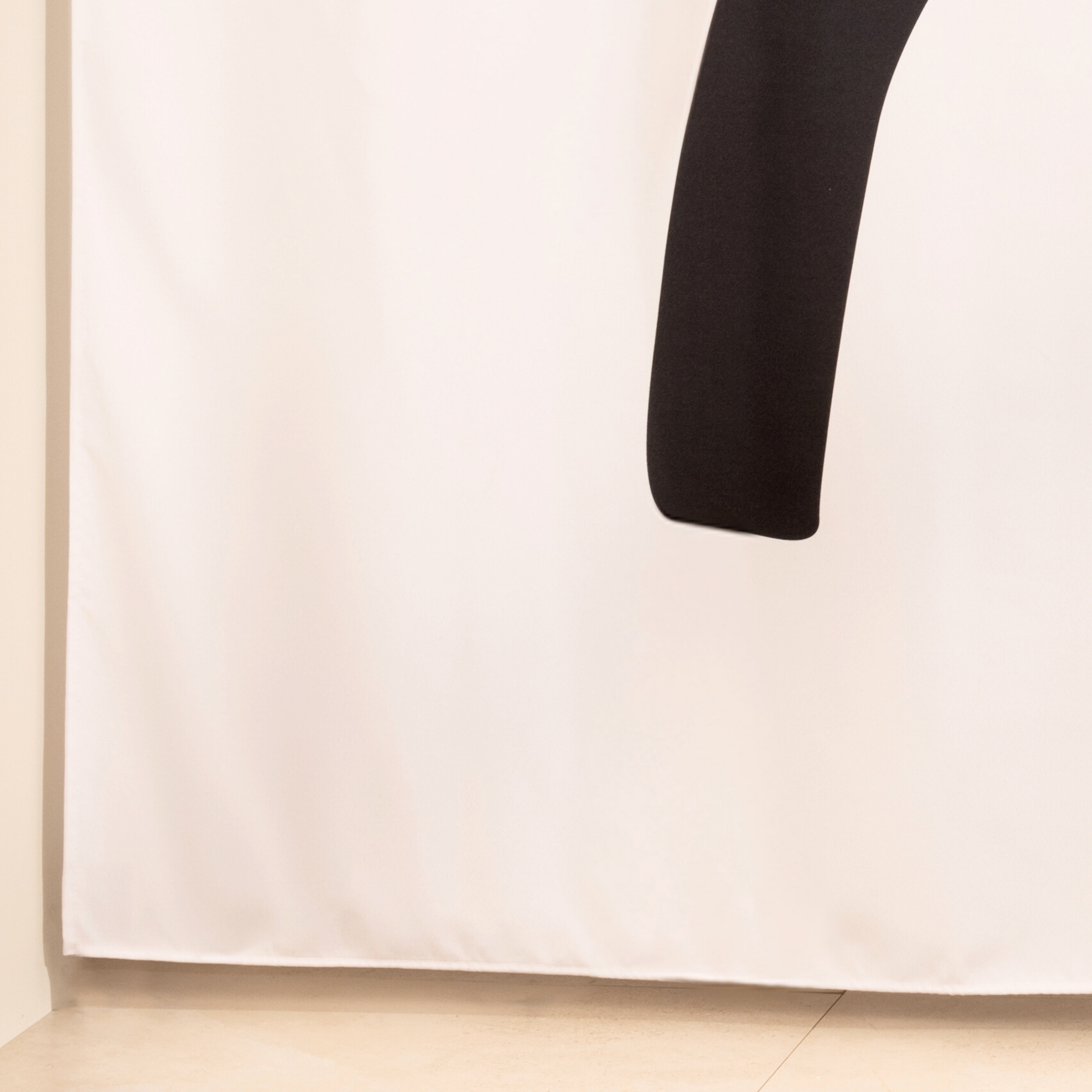 Full length bold abstract curtain hanging beside a glass screen