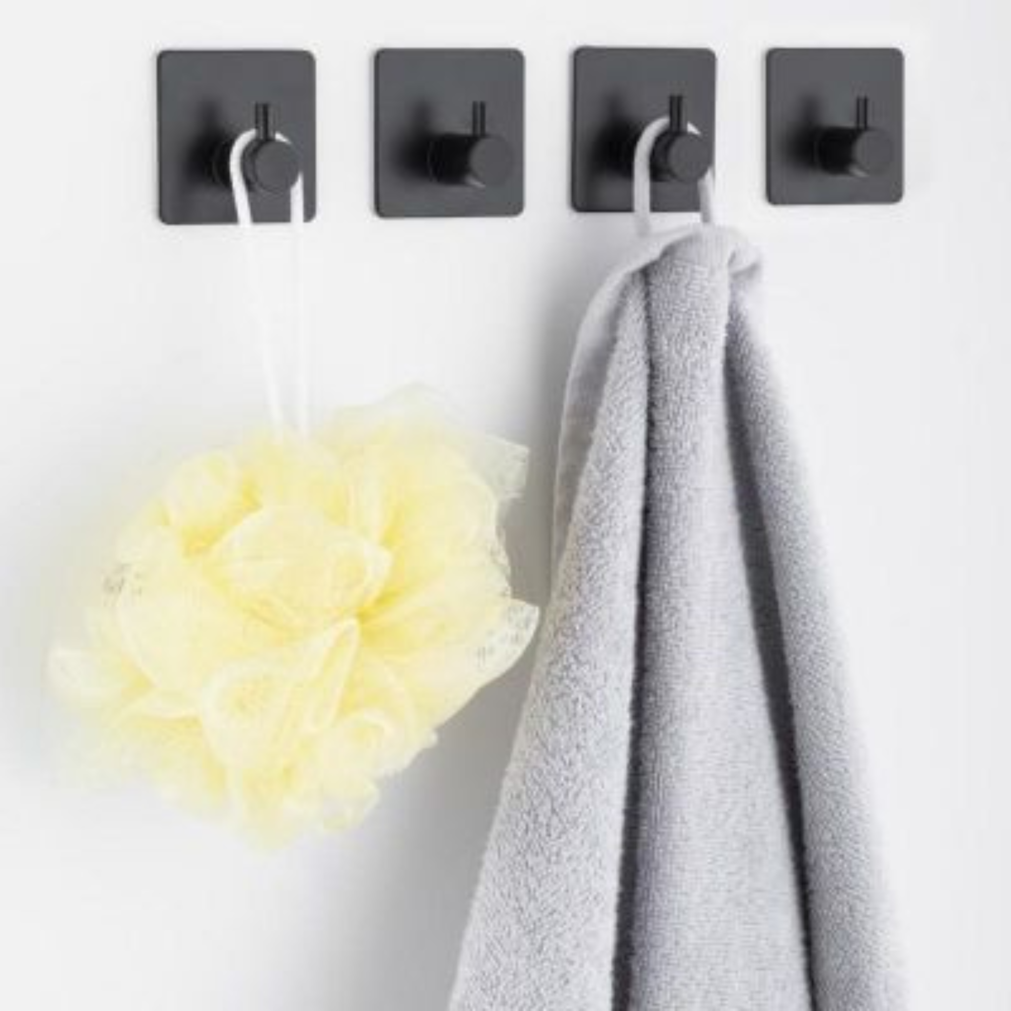 Side profile of the modern black hook against pale bathroom tiling
