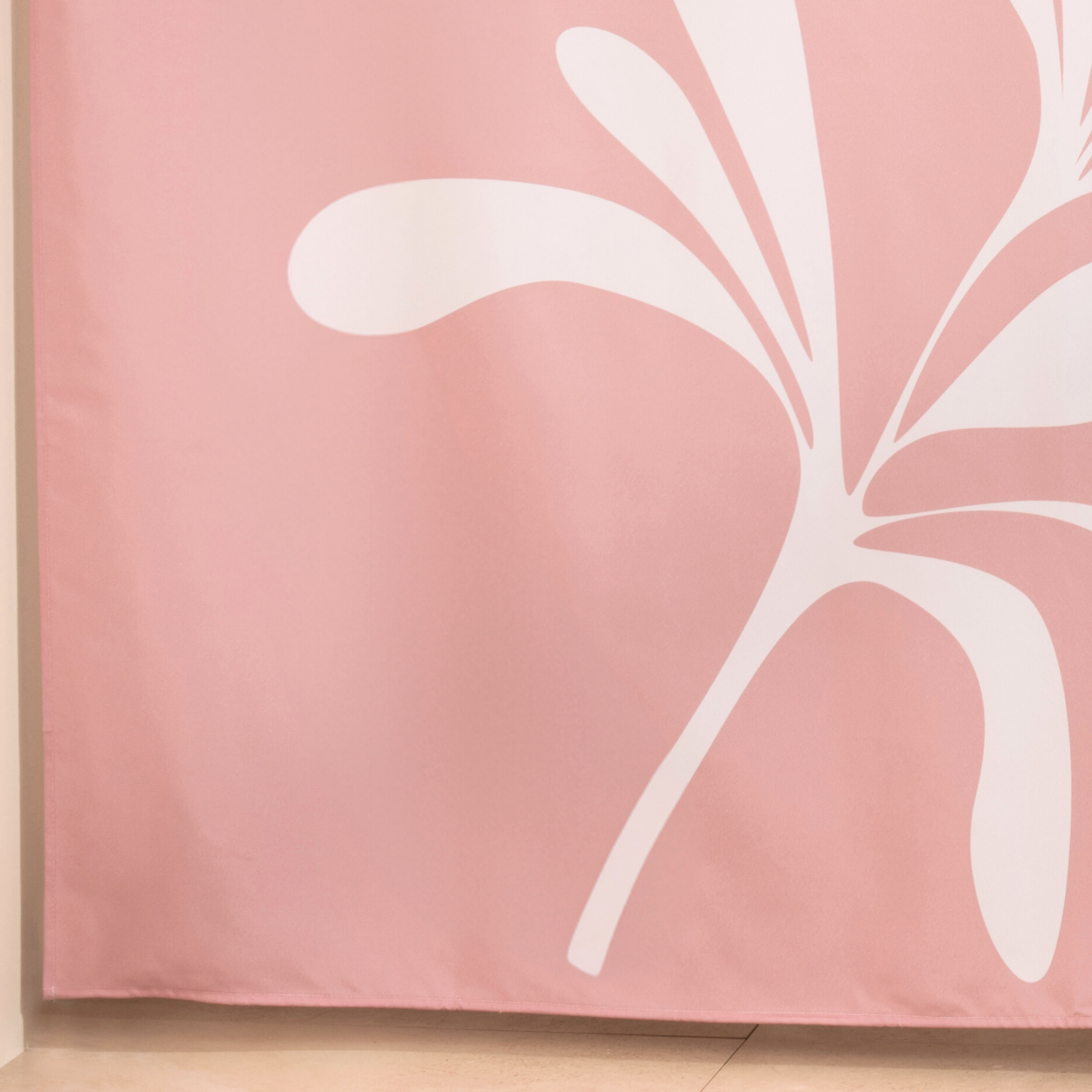 Full length organic shape curtain hanging beside a glass screen