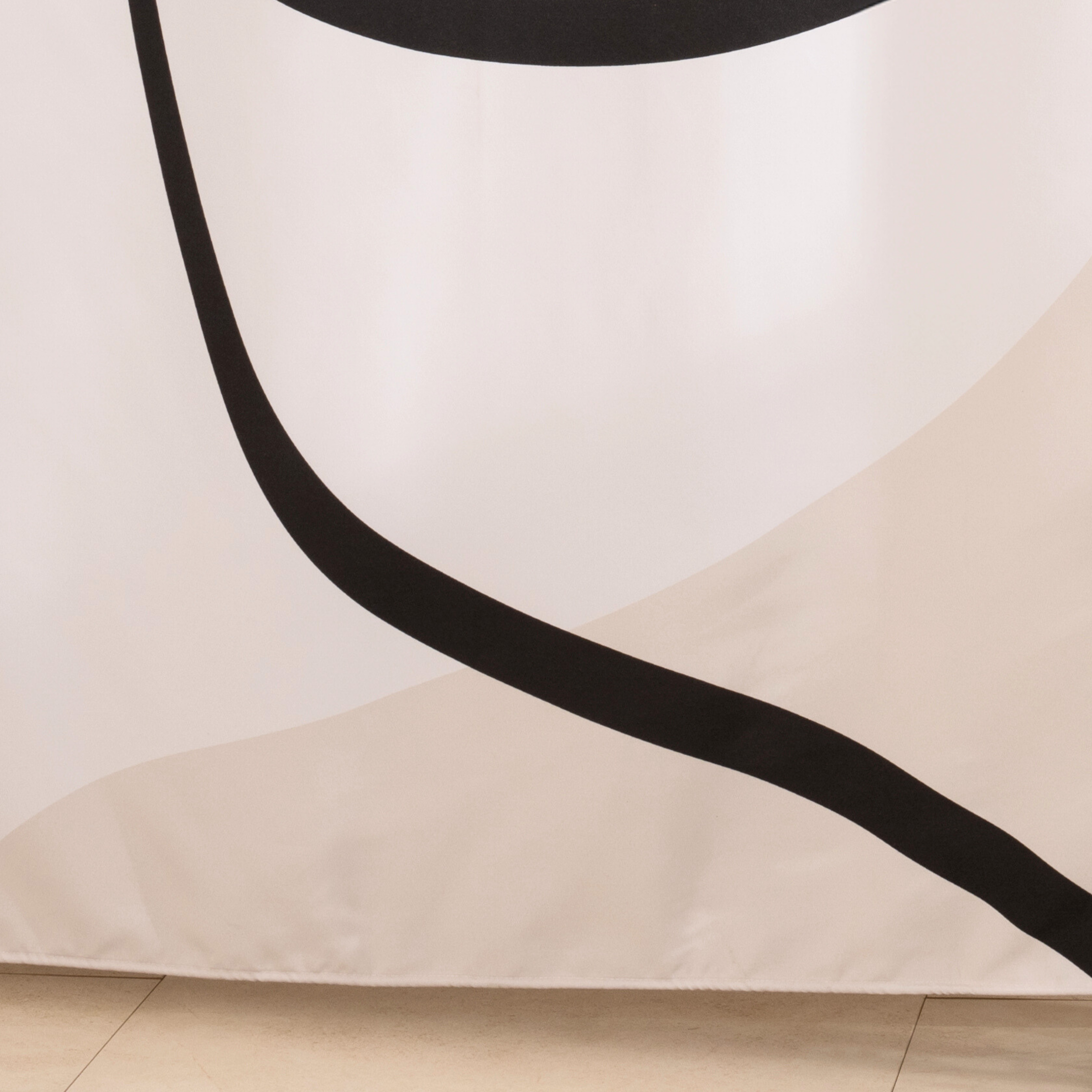 Full length minimal line curtain hanging beside a glass screen
