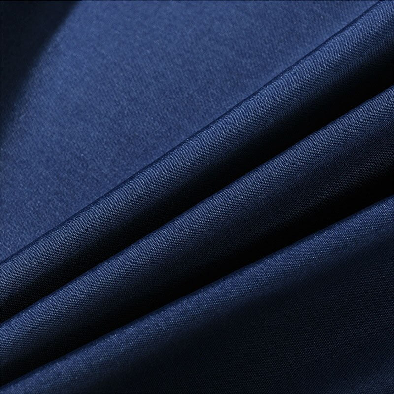 Full length navy cloth curtain hanging straight beside a white bath