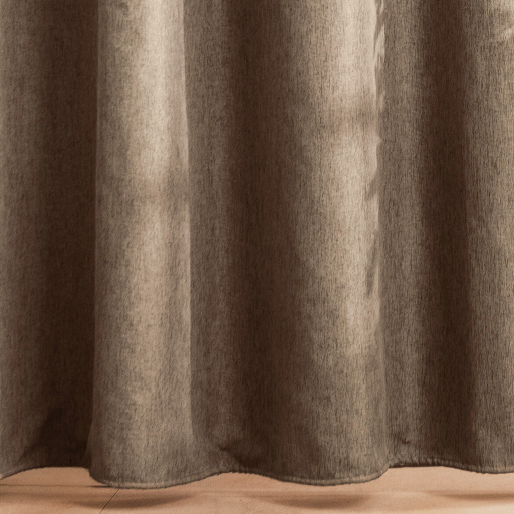 Full length greige curtain hanging beside a glass shower screen