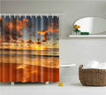 Wave breaking onto sand under an orange sunset sky with golden water reflections